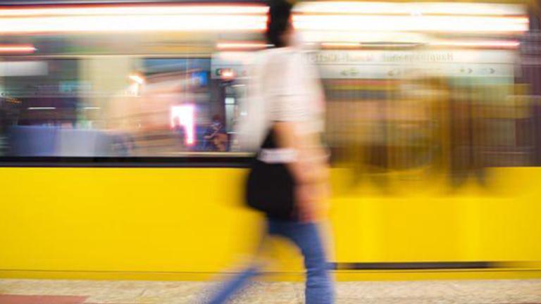 Mujer caminando en anden dentro de estación del metro